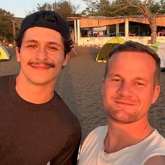 Dillon Ventura with a friend at a beach camp at sunset