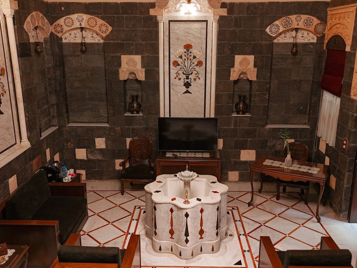 A salon in the hotel, with black and white stone walls and inlaid furniture